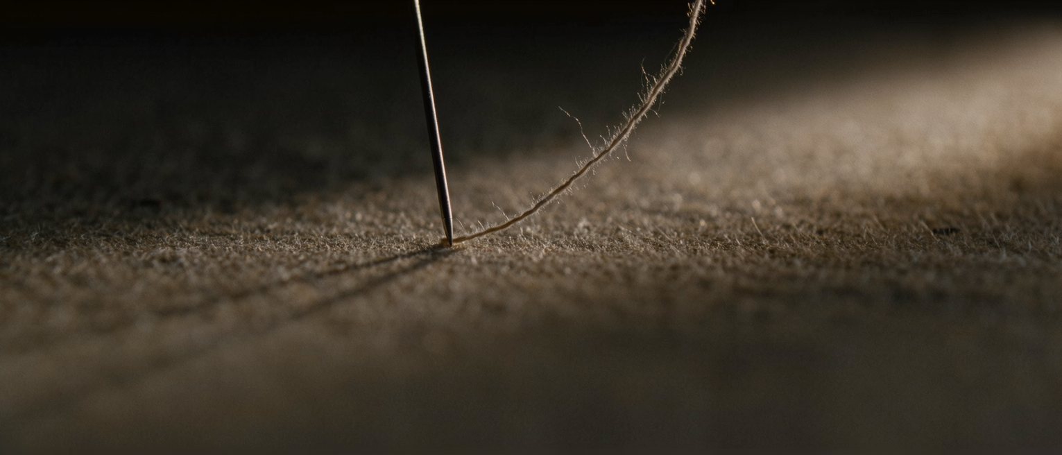 a length of thread under tension between two pins, slack at one end
