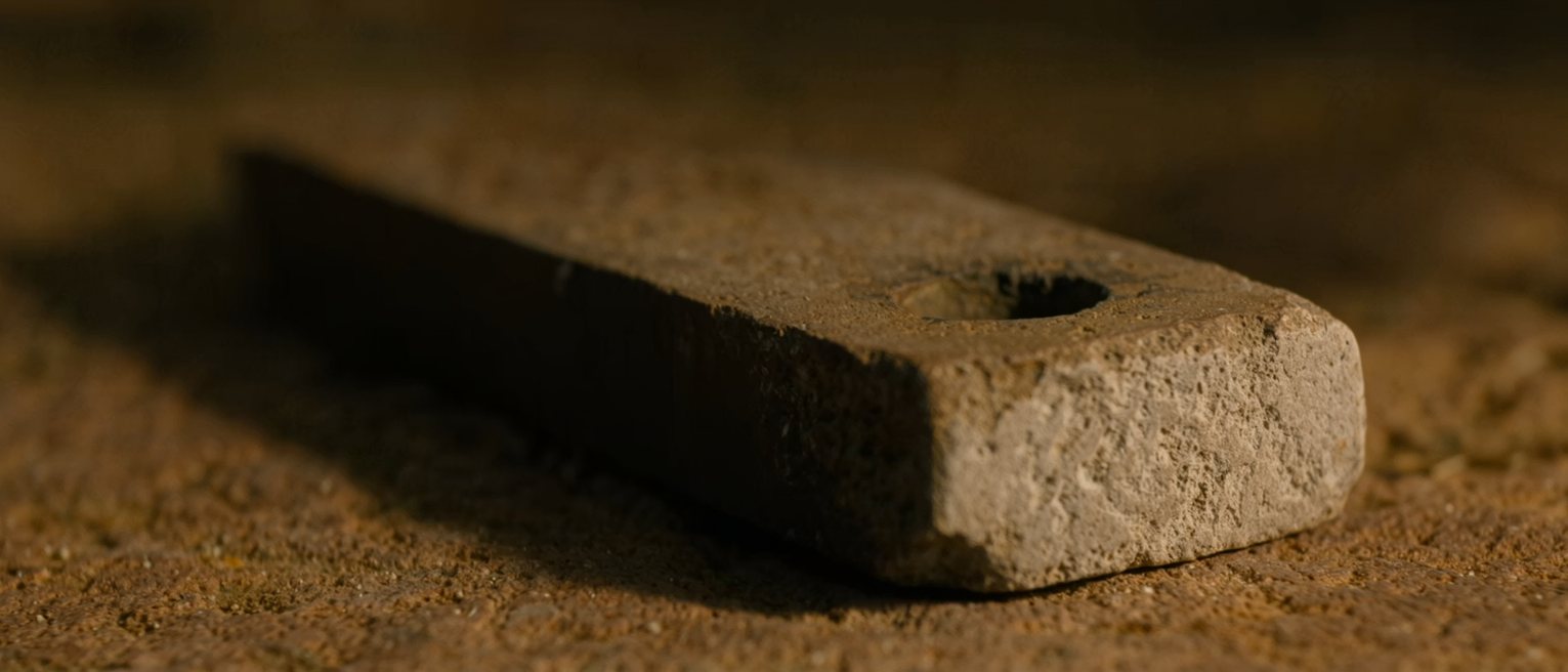 a whetstone worn hollow in the middle from years of the same stroke