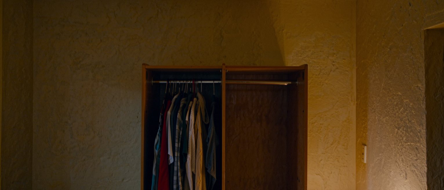 a wardrobe with one side full of clothes that were never her own choosing and the other side nearly empty