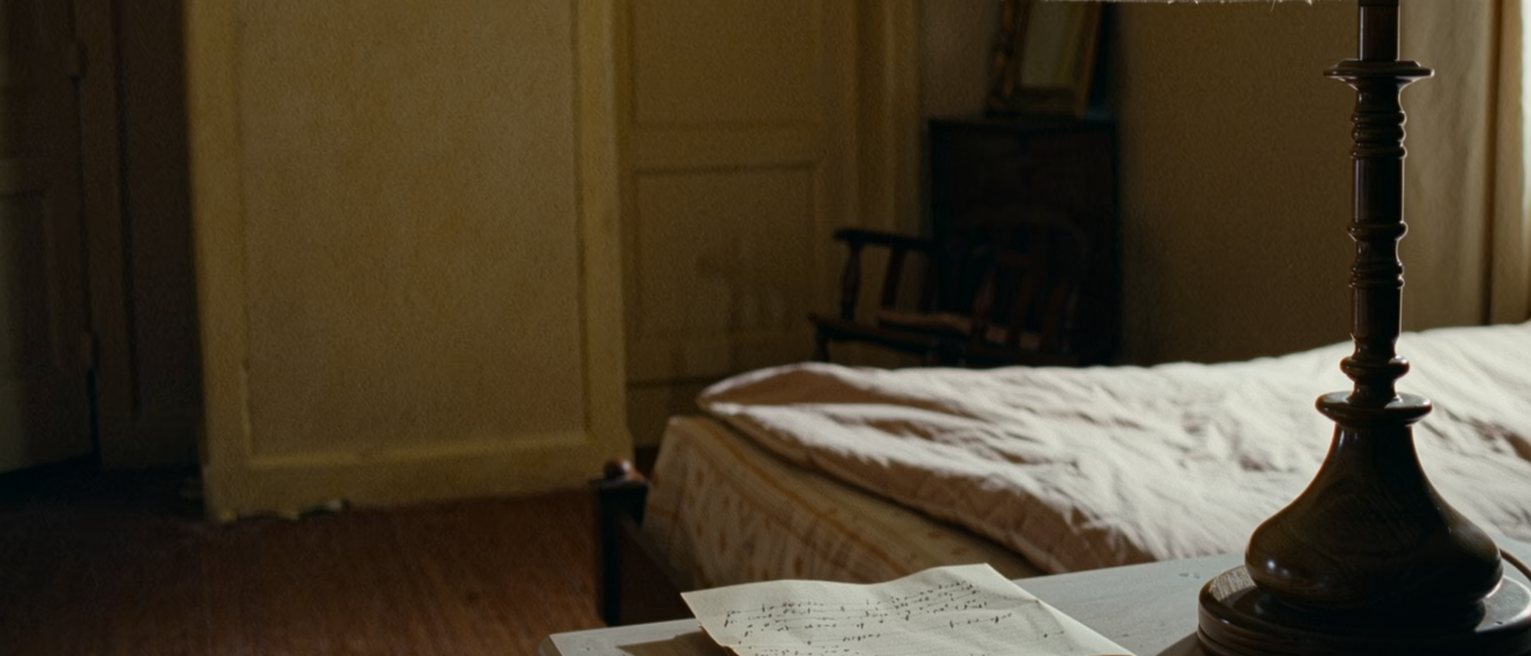 a bedside table with a written list folded in half and tucked under the lamp, and the far side of the bed turned down