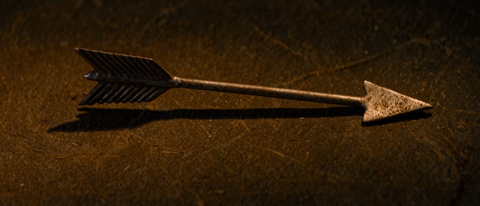 an iron weather vane arrow, its tail fins wide and its pivot clean
