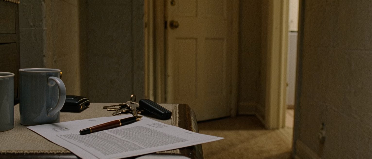 a hall table seen close with a postal survey envelope opened, its form filled and a pen, two mugs and a set of keys, the door soft behind