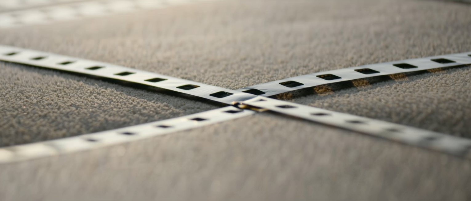 two lengths of film leader spliced together with tape, the join running across them