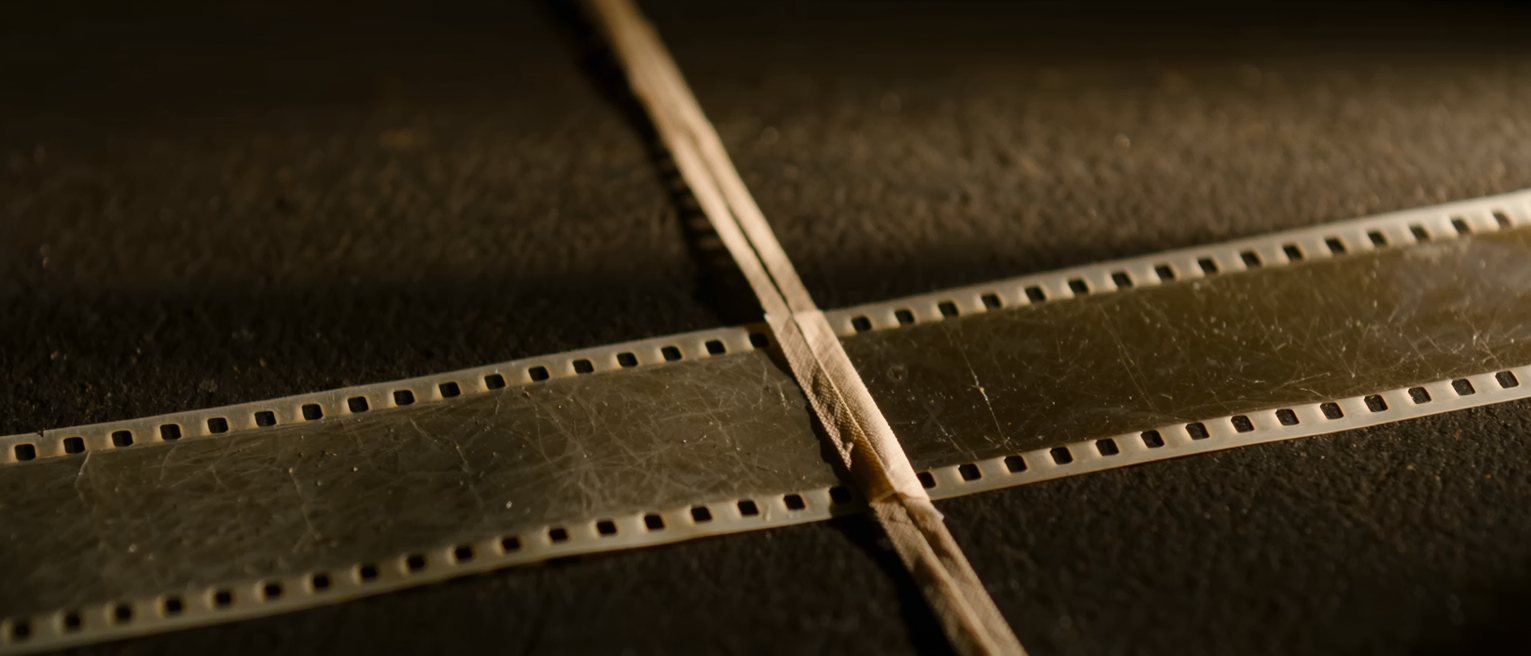 two lengths of film leader spliced together with tape, the join running across them