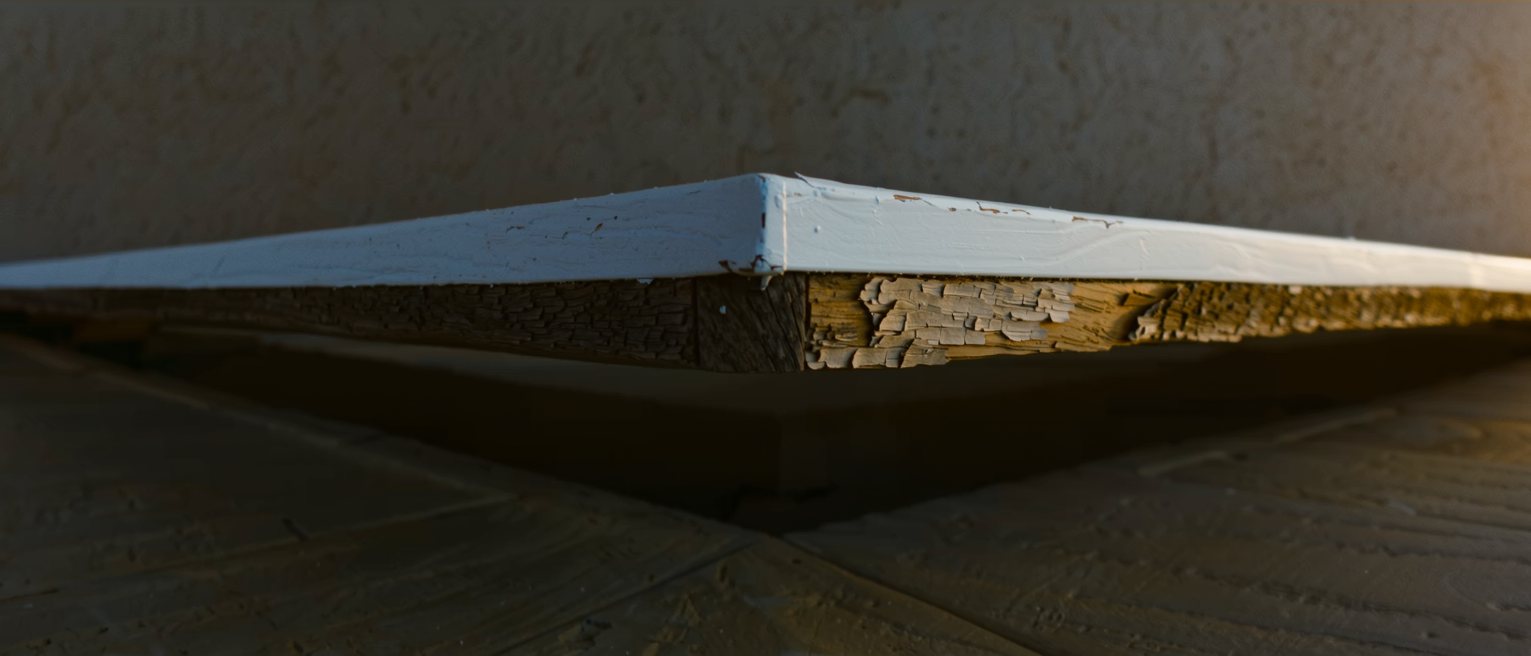 a painted porch rail with the paint whole on one side of a joint and flaked away on the other