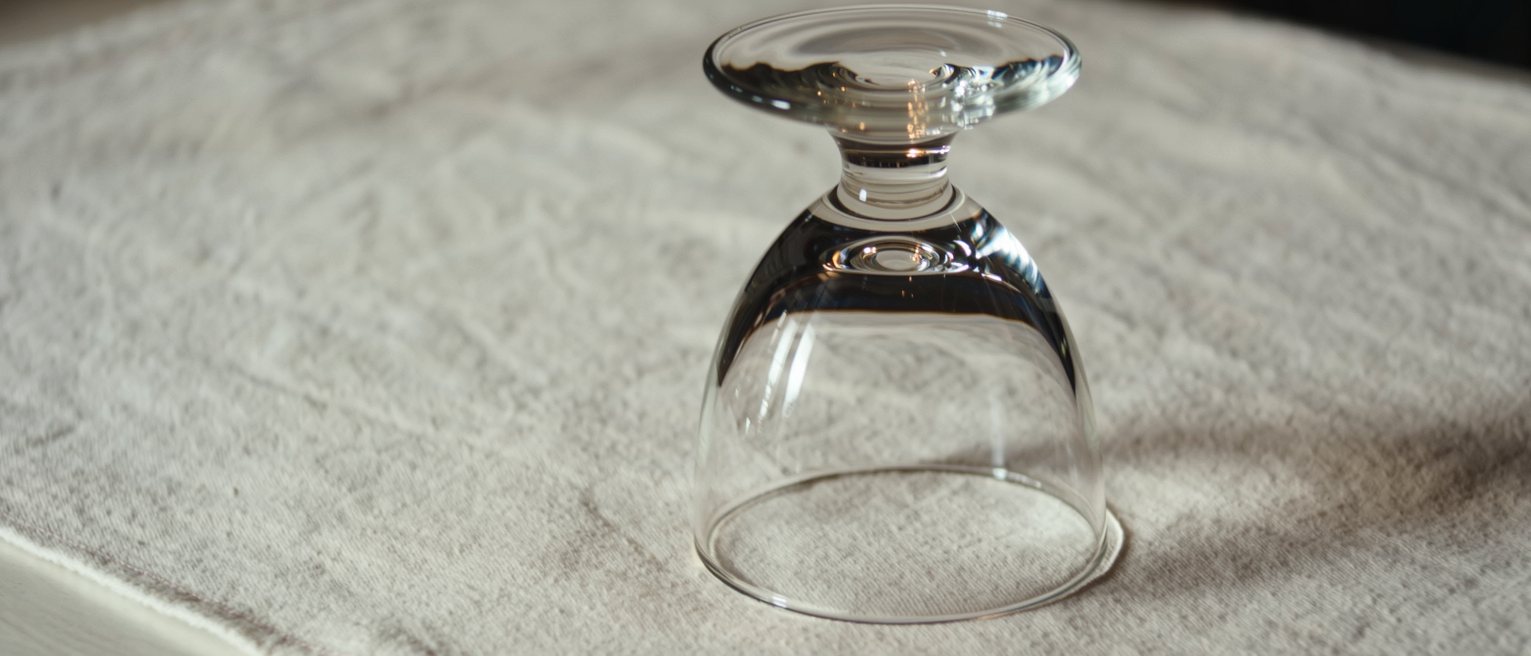 a clean drinking glass turned upside down on a bar towel, no ring left beneath it