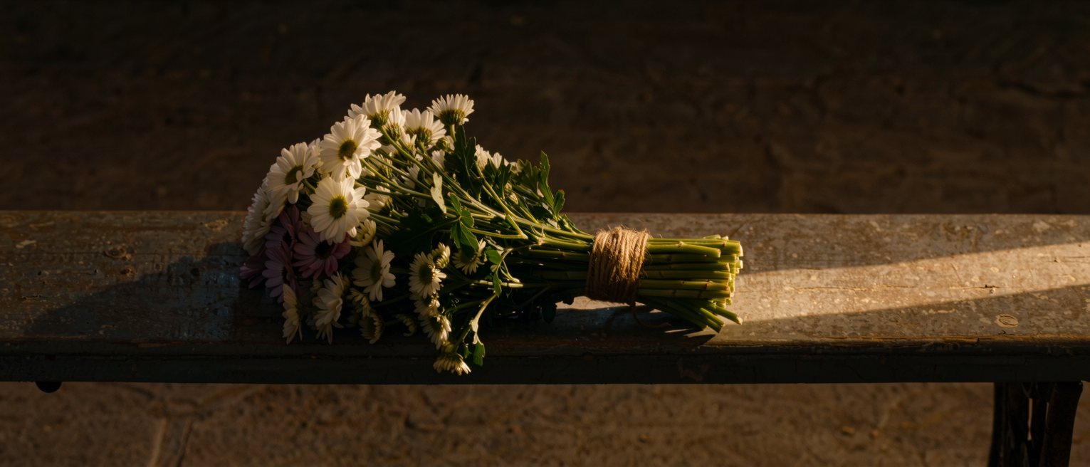 a bound bunch of cut flowers lying on a bench, every stem cut level