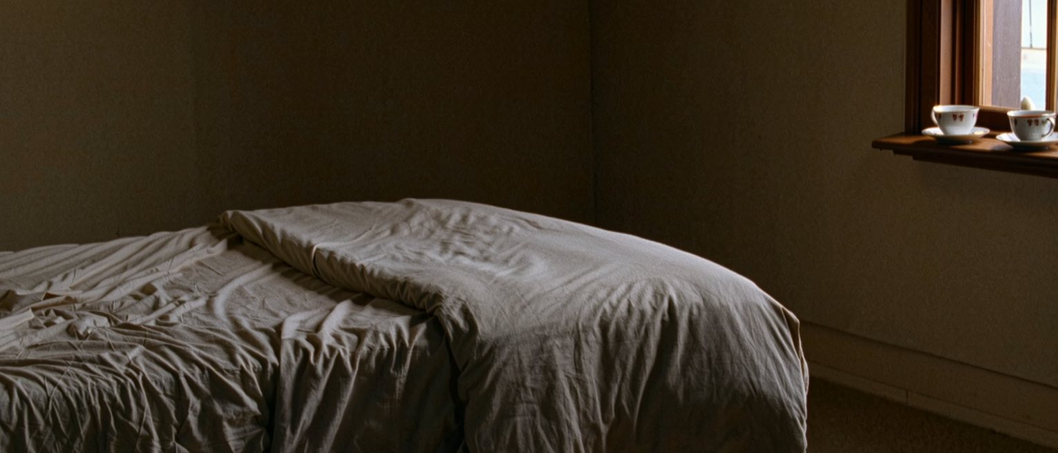 a bedroom with the covers turned down and then pulled straight again, two cups of tea carried in and set on the window sill