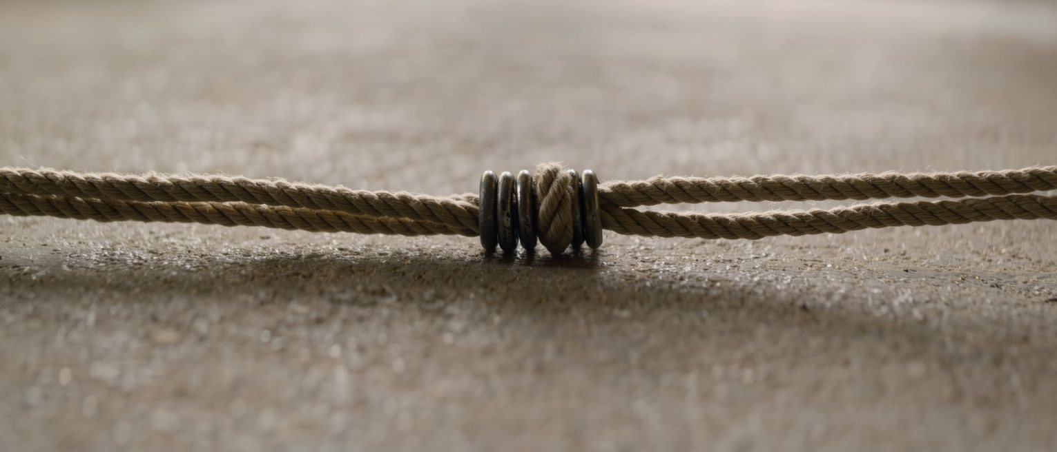 a length of cord tied between two iron rings so that moving one moves the other