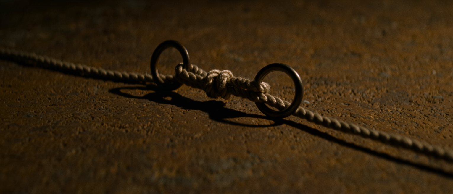 a length of cord tied between two iron rings so that moving one moves the other