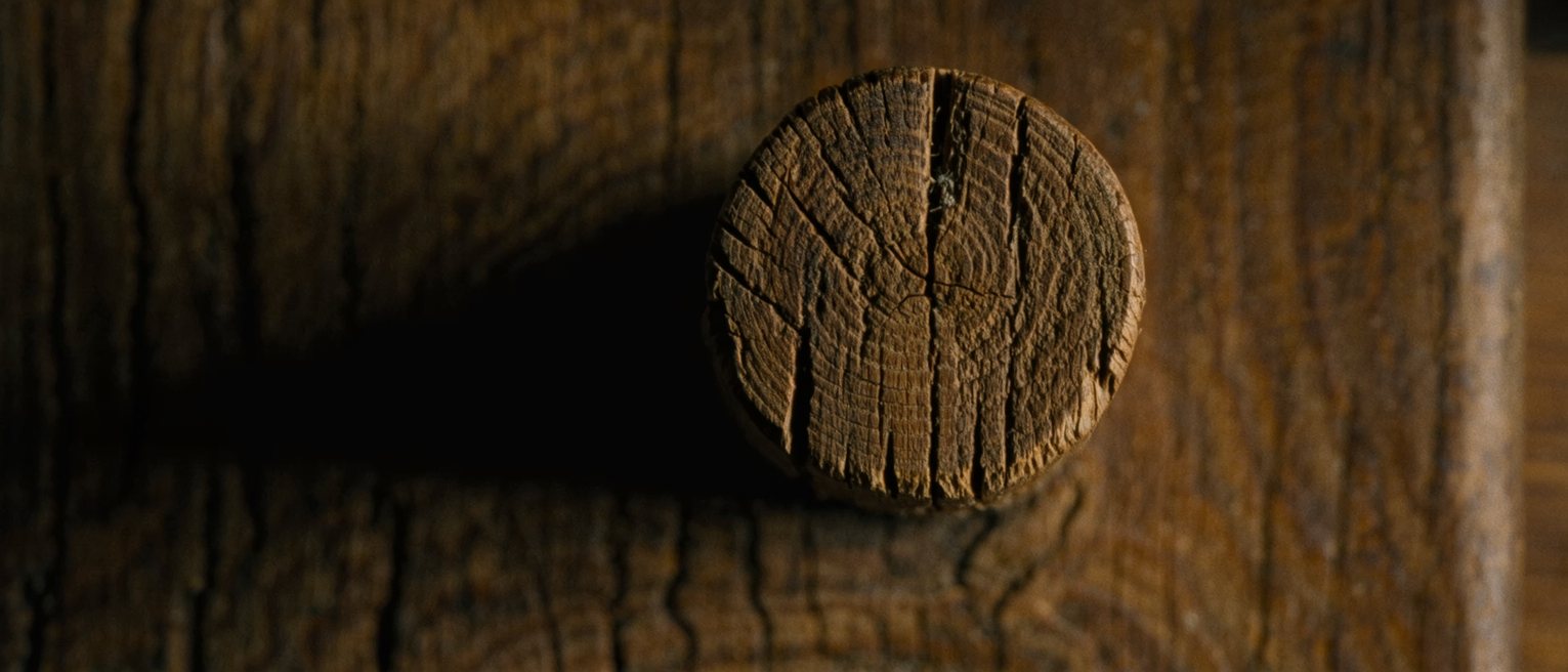 the head of an oak post with four beam tenons seated into it from four sides, the joint drawn tight with pegs