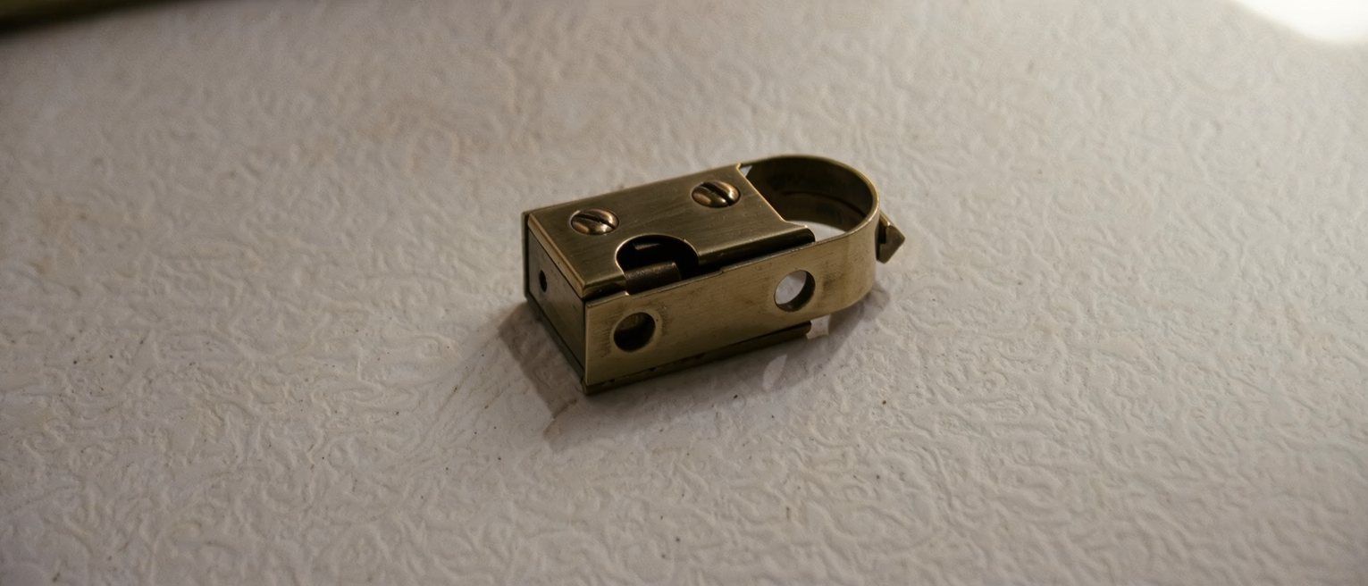 a brass door latch resting half engaged, free to move either way