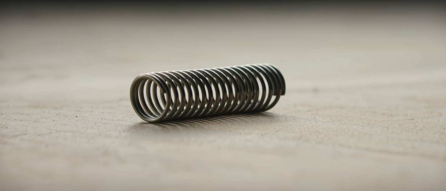a coiled steel spring released and lying slack, no longer under tension