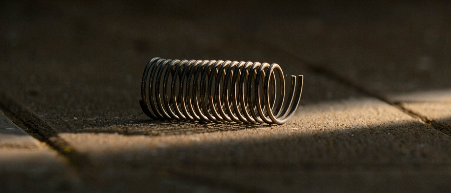 a coiled steel spring released and lying slack, no longer under tension