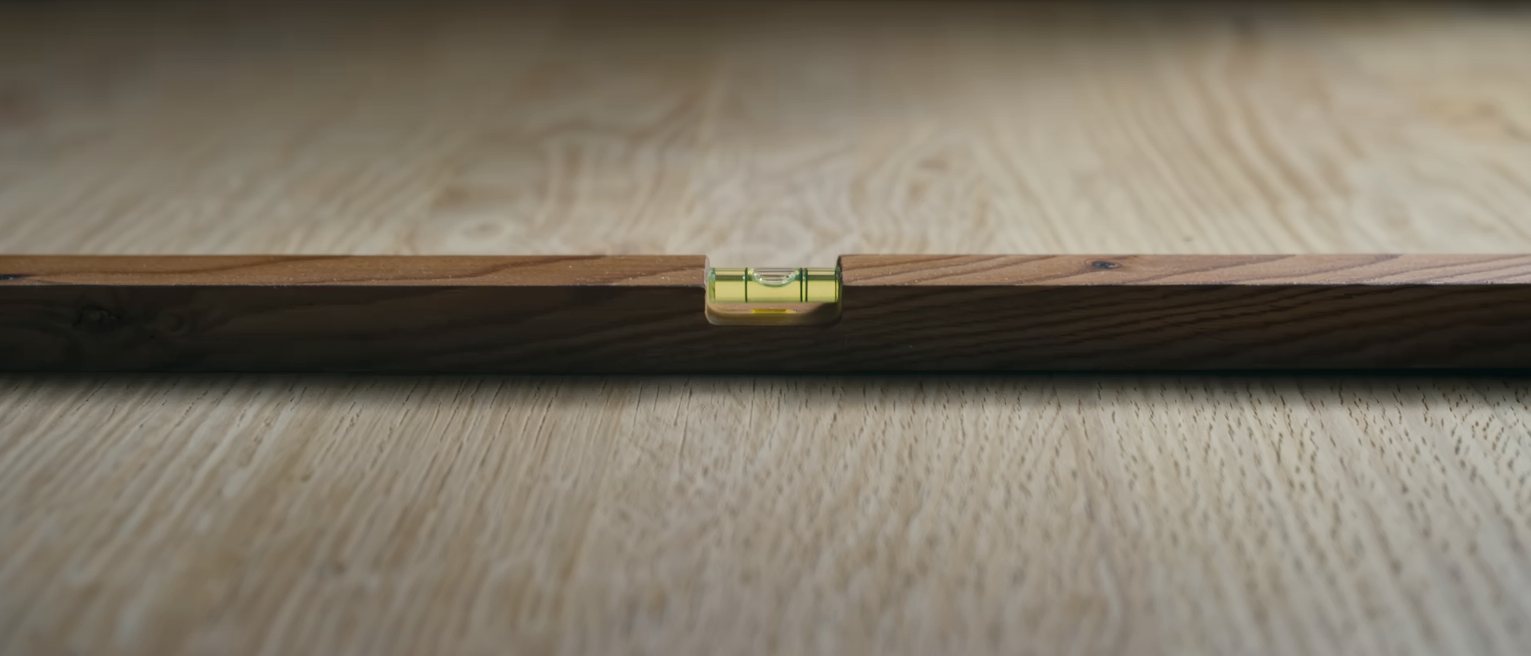 a spirit level resting true on a planed beam, the bubble dead centre