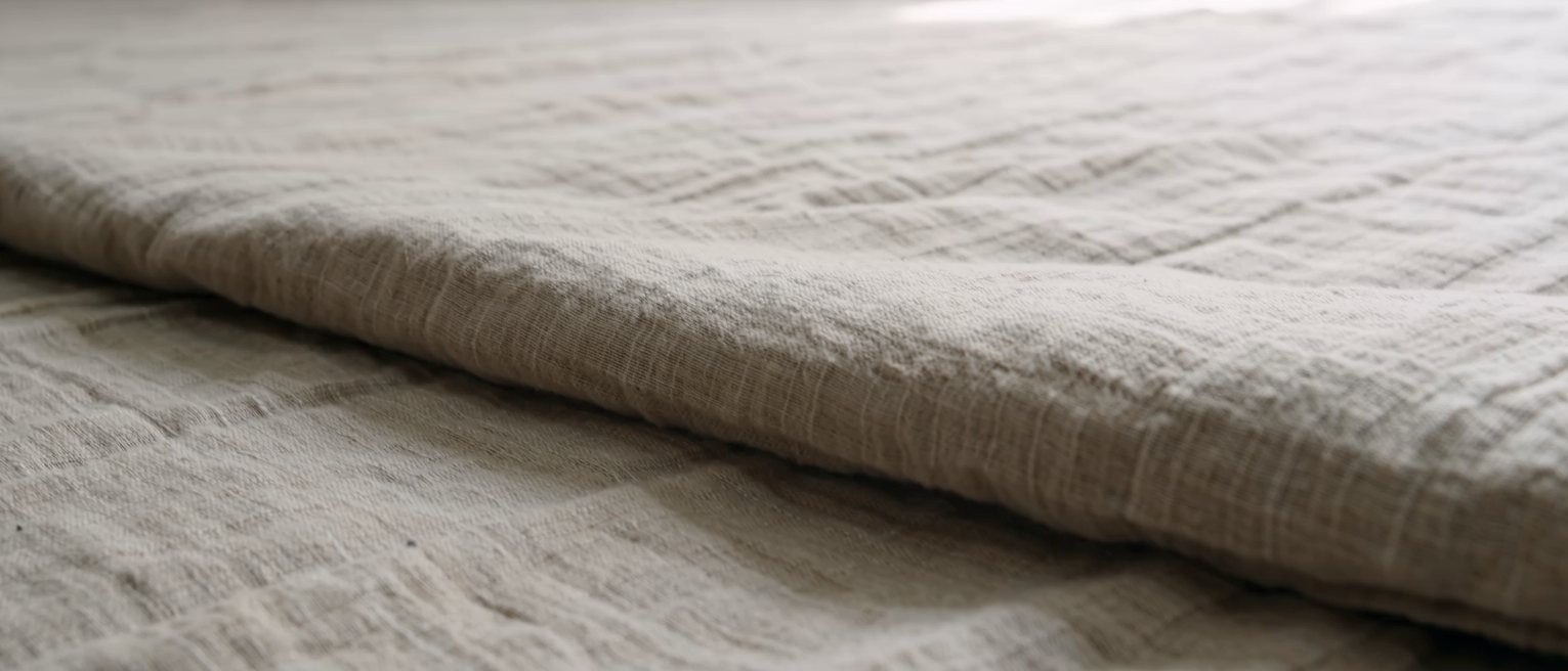 a heavy linen sheet pulled back and left open, the folds holding their shape