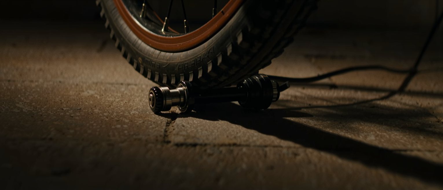a bicycle dynamo bearing on the tyre with the lamp bracket beside it