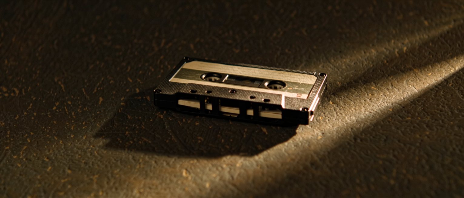 a cassette tape out of its case with a blank unwritten label, the tape wound hard to one side