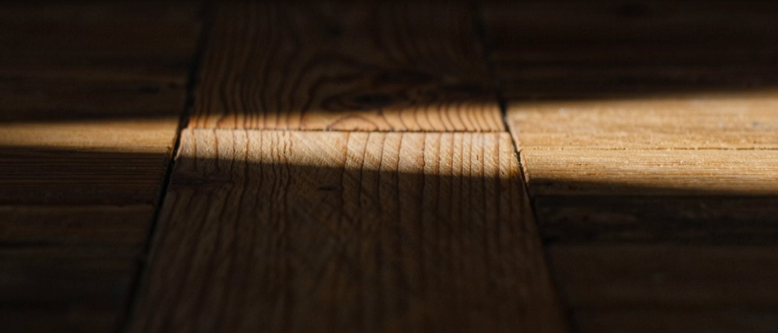 a wooden floorboard with one plank slightly proud of the others, never planed down
