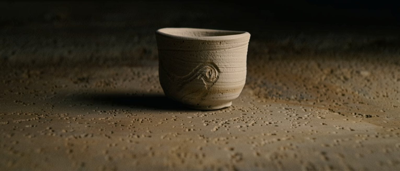 a hand-thrown cup with a thumb-mark left in the clay and fired that way