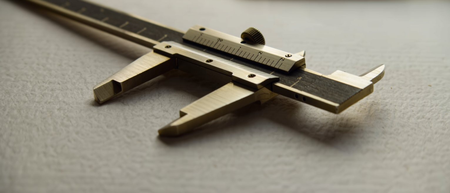 a pair of brass calipers set to a measurement and locked