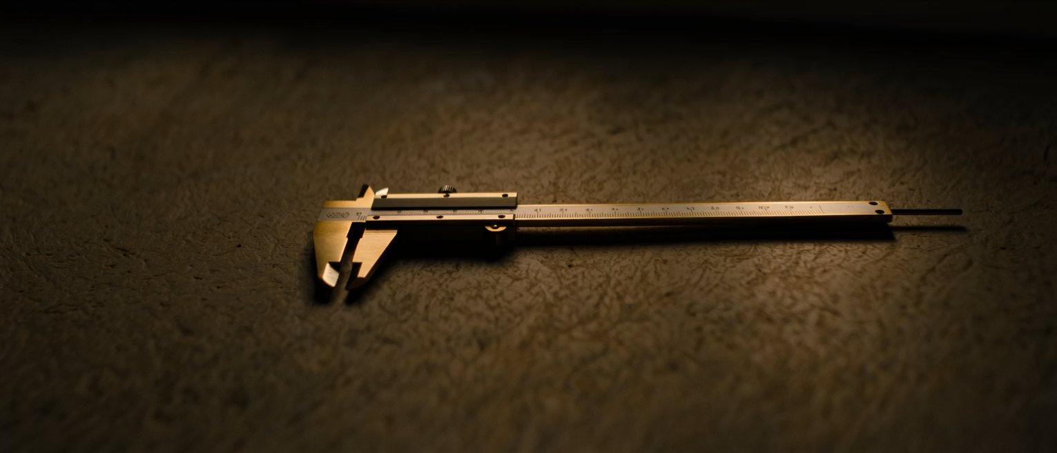 a pair of brass calipers set to a measurement and locked