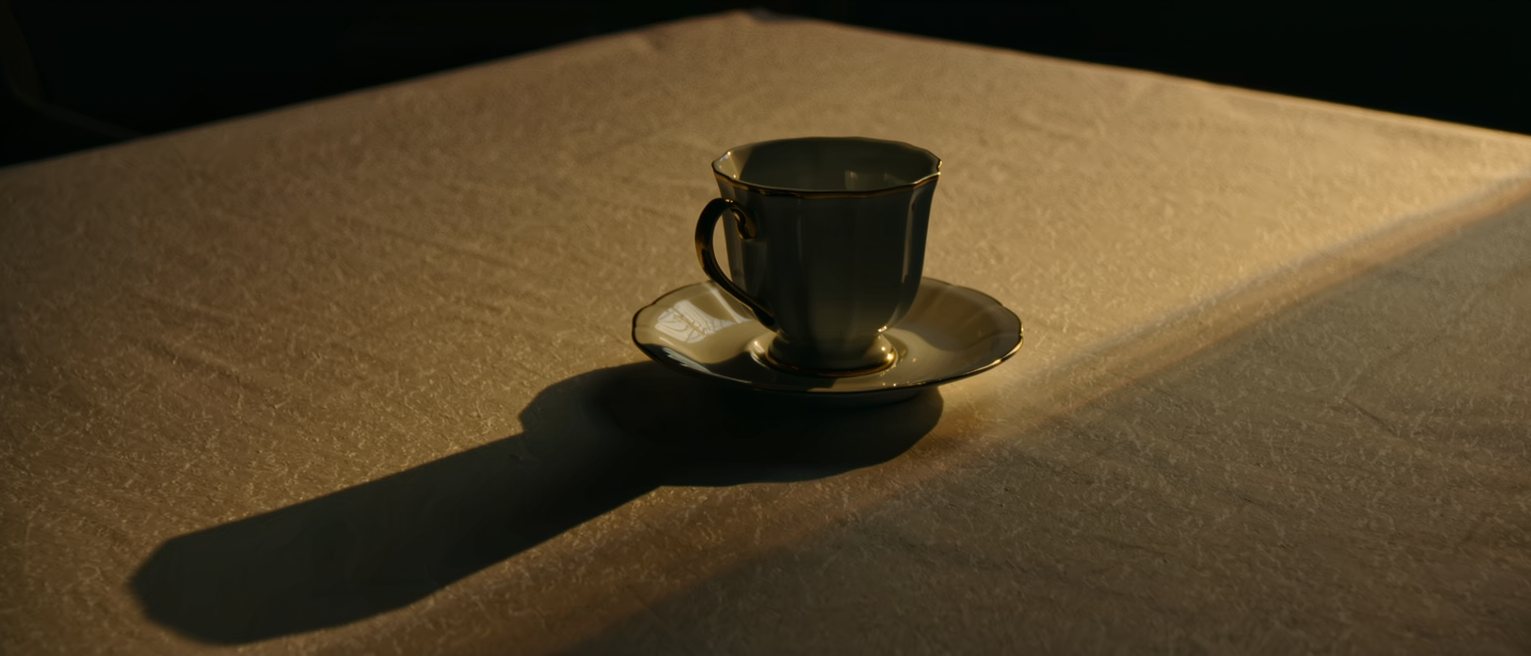 one cup and one saucer set out on a clean table, the cup turned upright