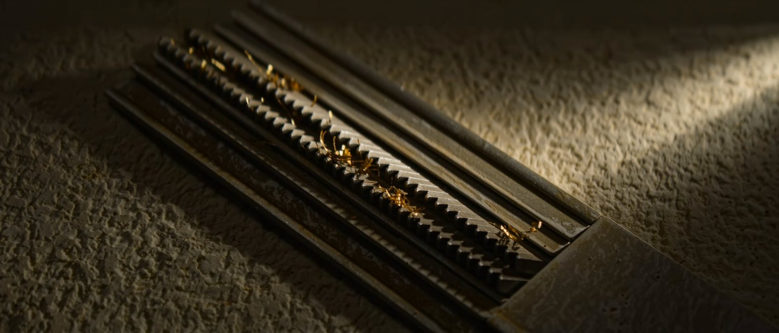 the cut teeth of a steel file with brass swarf caught between the rows