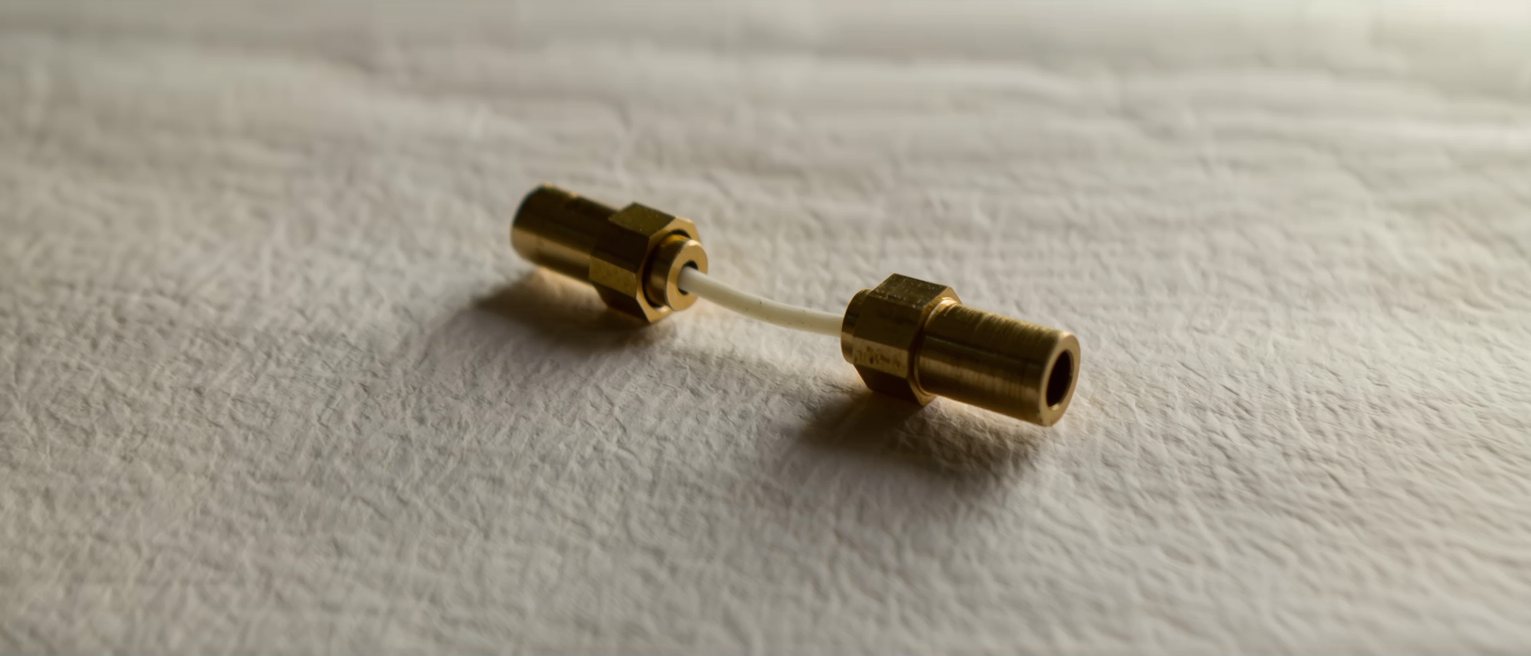 two brass terminals set apart on a board with one wire run between them