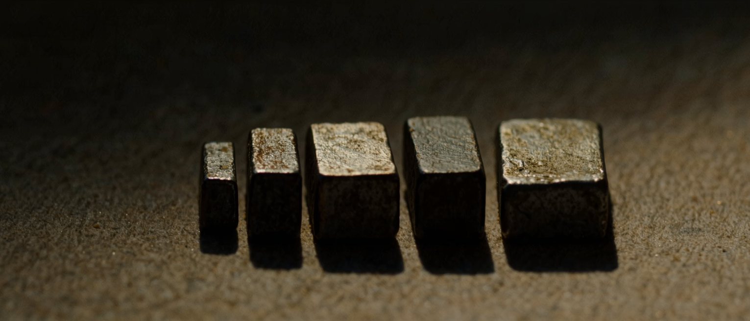 a set of gauge blocks laid out in a row, each one a different thickness