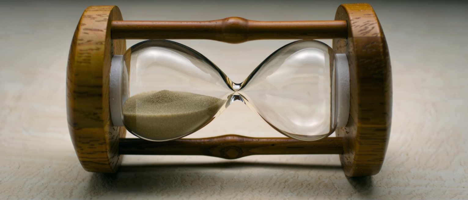 a sand glass in a turned wooden frame, the sand part run through