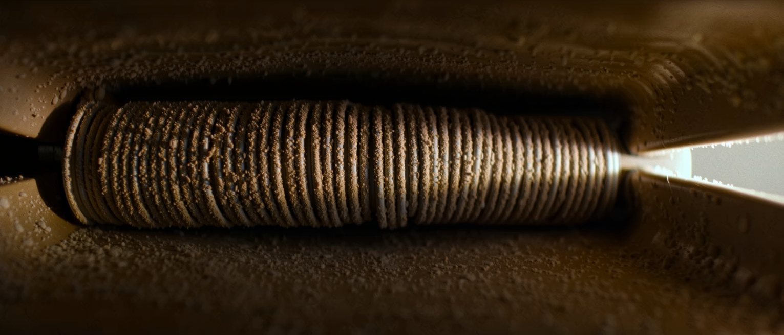 the wire condenser coils on the back of a refrigerator, dusty and warm