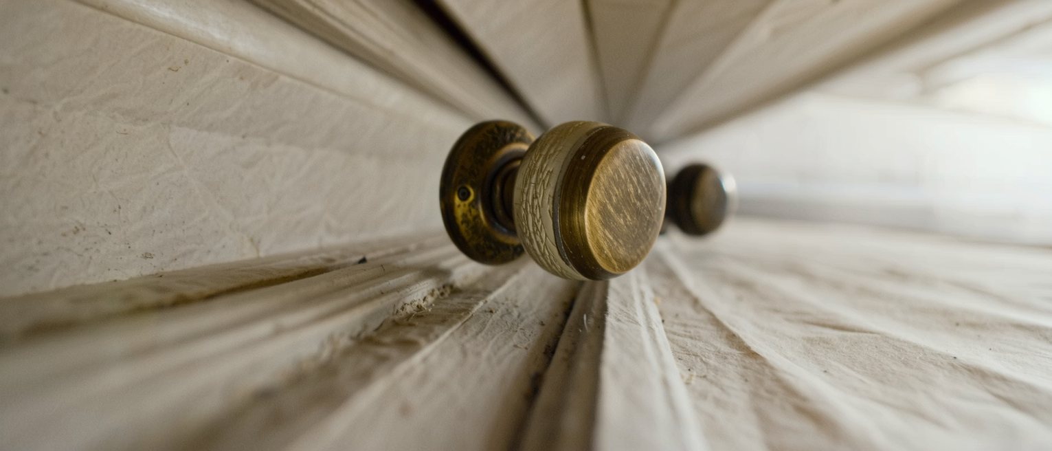 a brass door handle worn down to a paler metal along one side