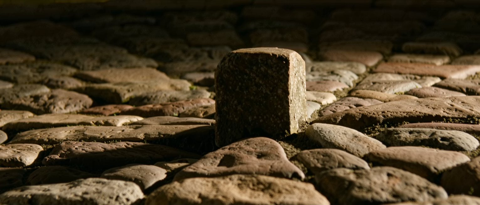 a keystone set at the crown of a stone arch, every other stone leaning on it