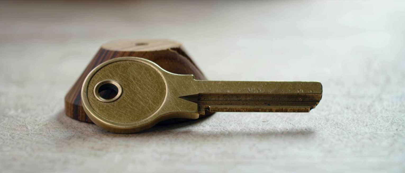 a brass telegraph key on a wooden base, its contacts pressed closed