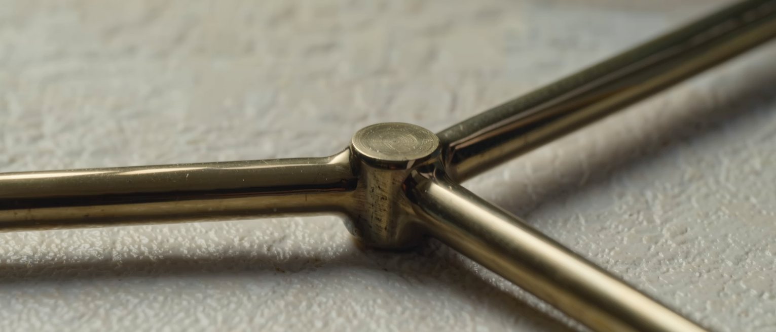 a brass turnstile arm, its three limbs at rest