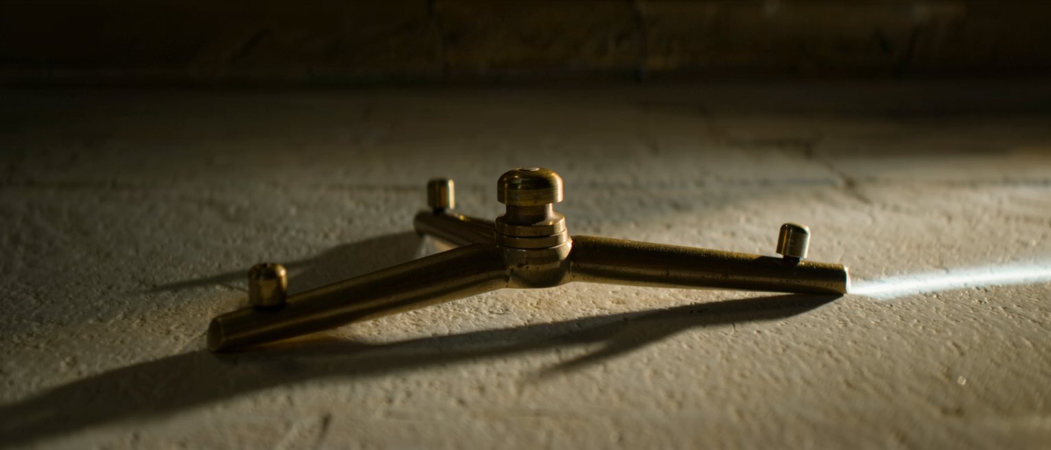a brass turnstile arm, its three limbs at rest