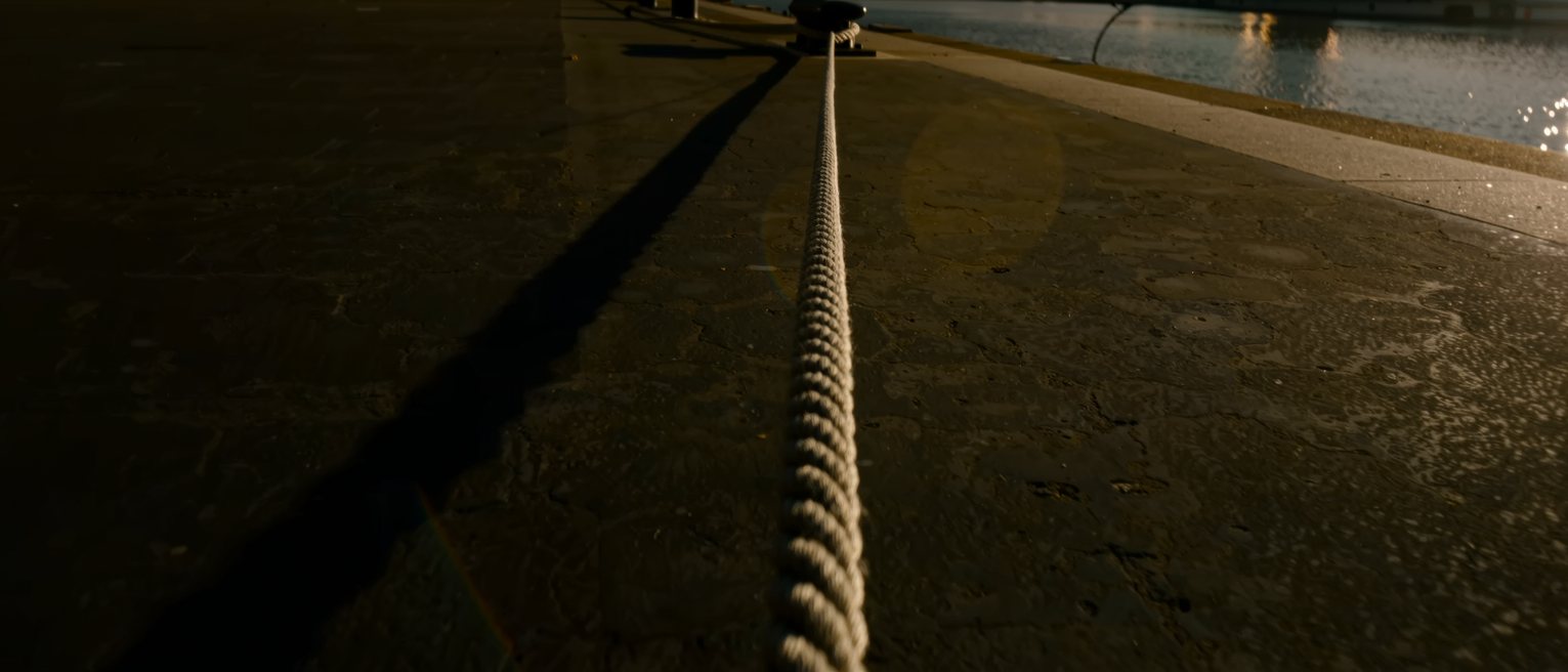 a mooring rope pulled taut from a bollard, running out of frame over water
