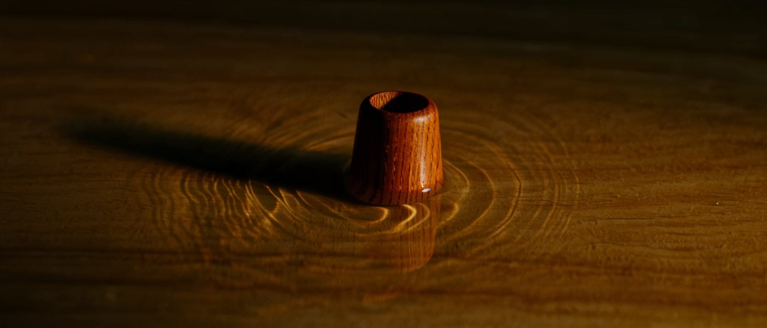 a cypress wood bathing dipper floating upright in still water