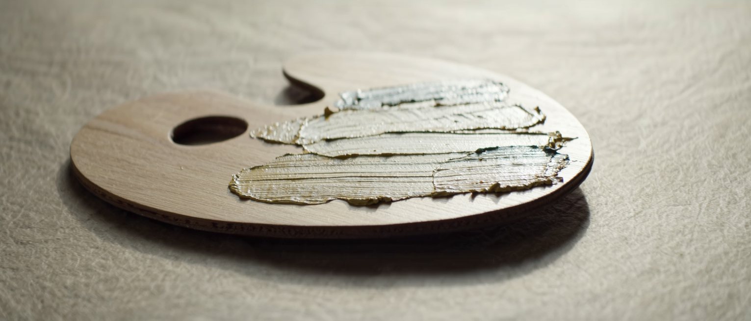 a wooden painter's palette with dried ridges of oil paint across it and no brush laid on it