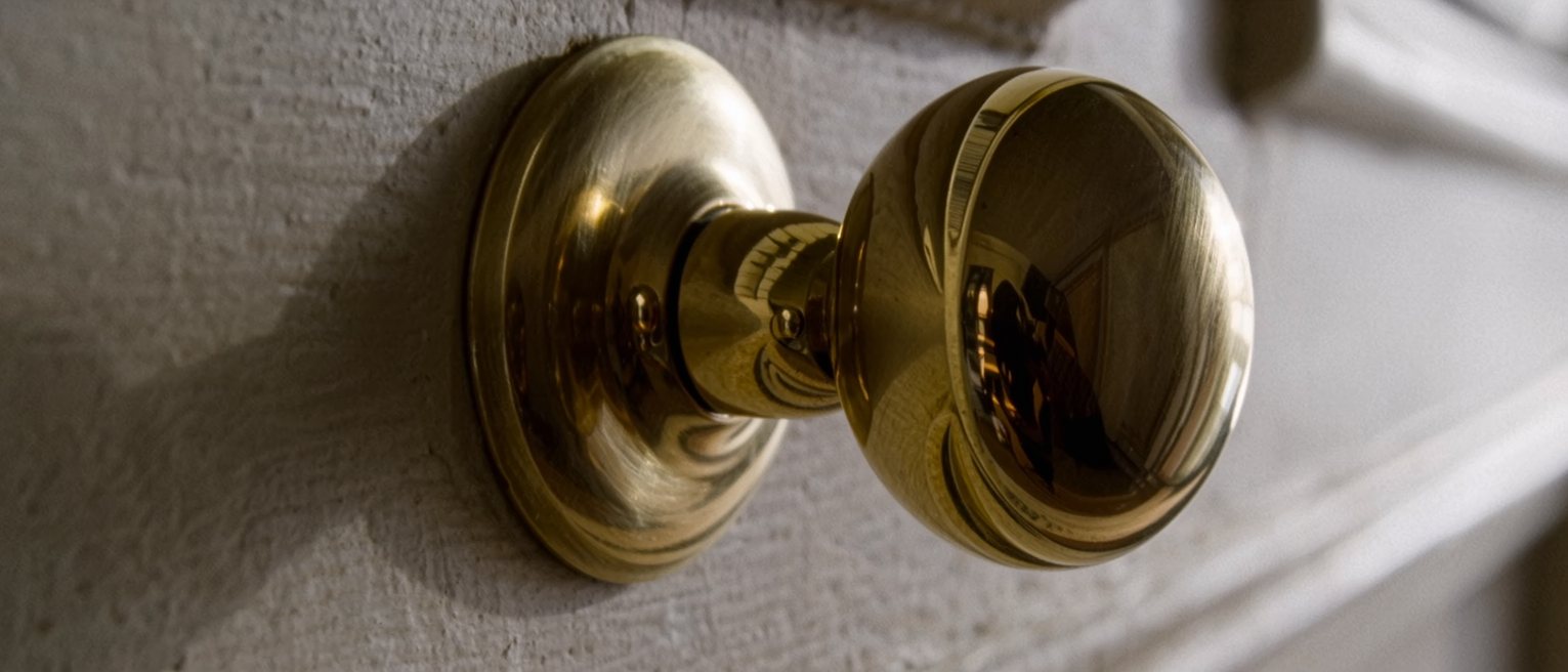 a heavy brass door handle polished bright at the grip and left dull everywhere else
