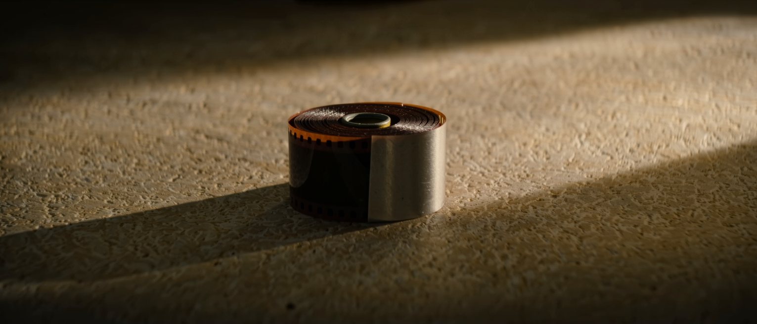 a roll of unexposed film in its metal canister, the leader still tucked in