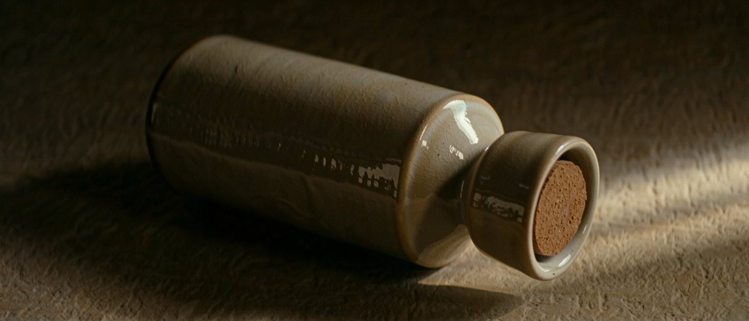 a glazed stoneware hot-water bottle with its stopper screwed home