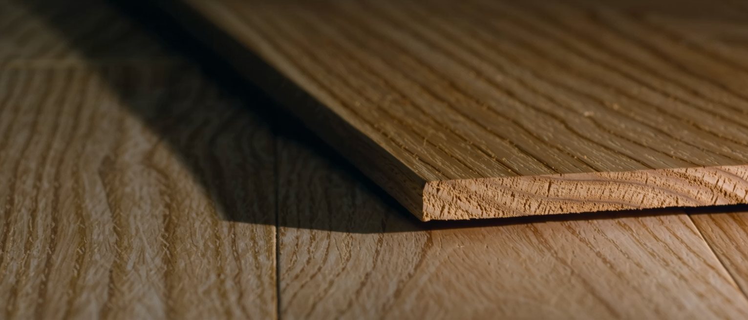 a floor of bare boards scrubbed pale, one board replaced and newer than the rest