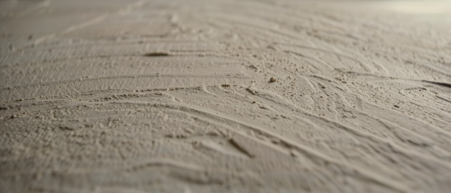 a plastered wall left with the trowel marks showing and never rubbed down