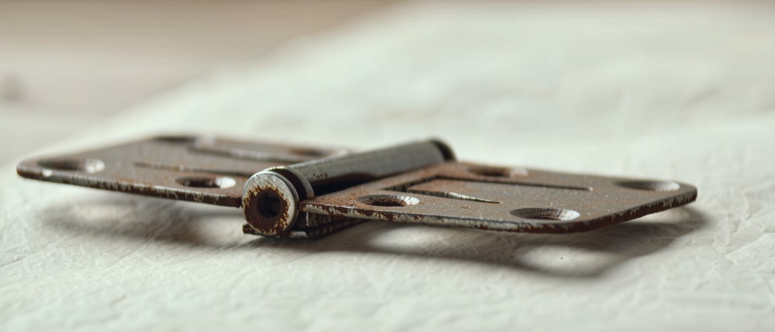 an iron gate hinge worn bright at the pin where the rust has been rubbed away by turning