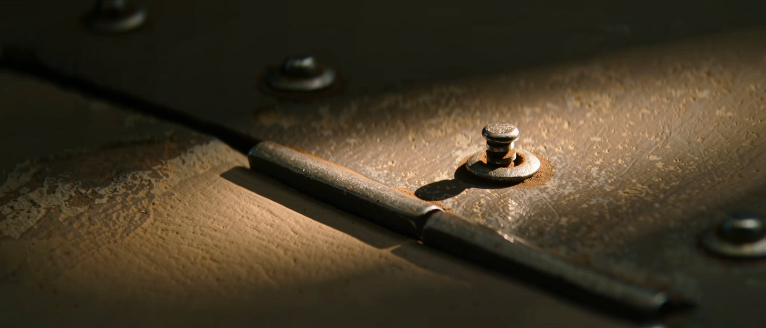 an iron gate hinge worn bright at the pin where the rust has been rubbed away by turning