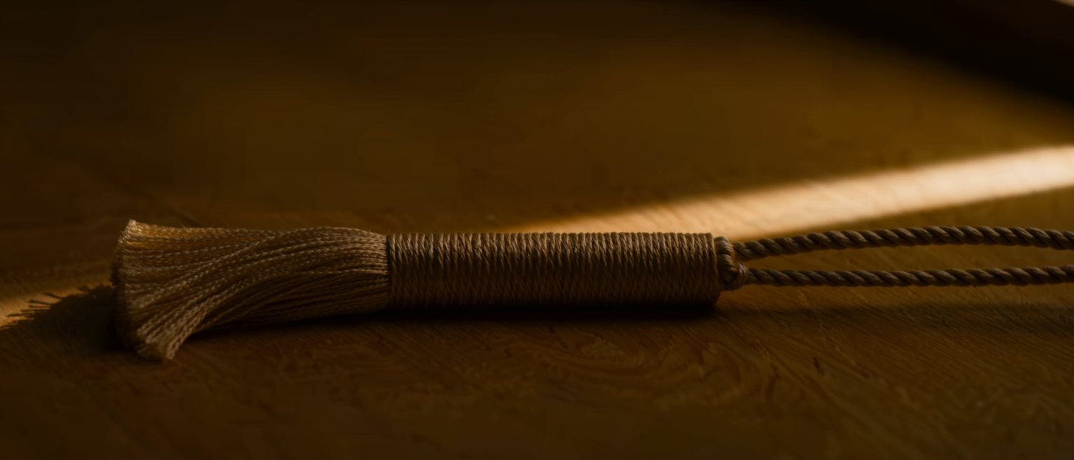 the cord and tassel of a rolled bamboo blind, tied off at the bottom