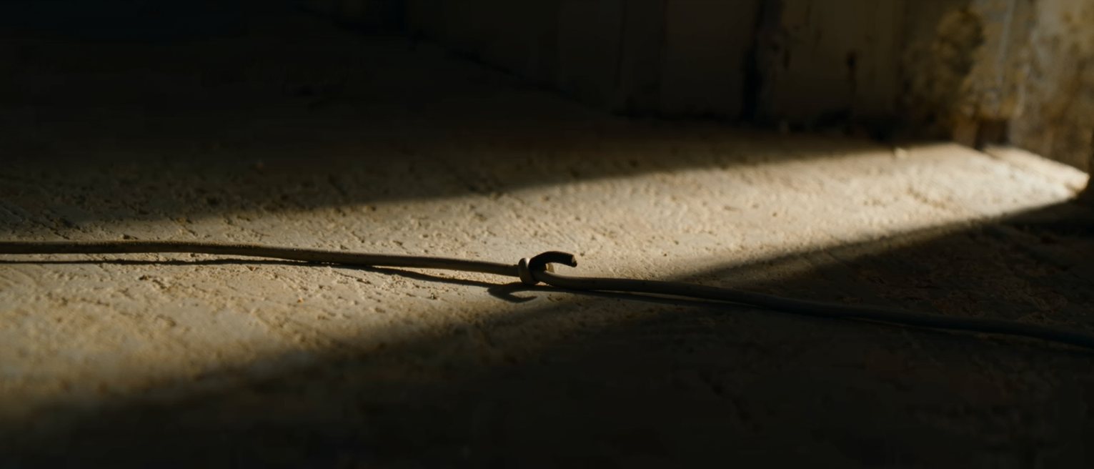 a bell wire running along a skirting board, one end unhooked from its lever