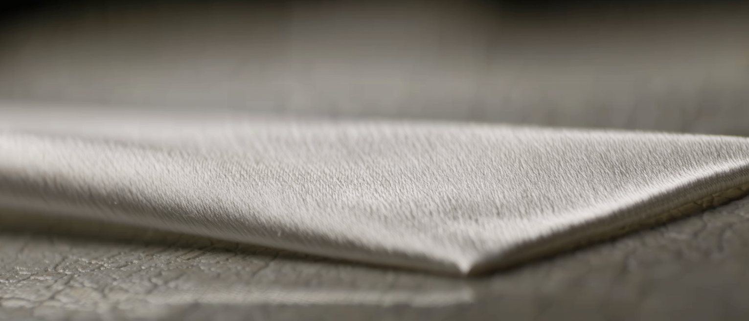 a sheet of silk pinned taut at its corners, the weave pulled dead straight